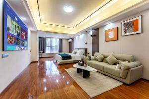 广州東枫国际公寓(广州萝岗万达广场苏元地铁站店)的客厅配有沙发和1张床
