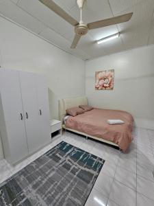 哥打巴鲁Ruhani Homestay 3 KB - 4 Bedroom Fully Airconditioned with WIFI & Netflix的一间卧室配有一张床和吊扇