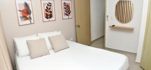 巴兰基亚Excelente ubicación y cómodo apto, perfecto para ti!的一间卧室配有带白色床单和枕头的床。