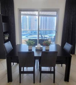 迪拜Full Marina View 2BR Luxury Apartment的一间带桌椅和窗户的用餐室