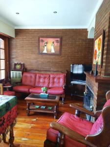 内科切阿Casa a 2 cuadras de la playa的客厅设有红色的沙发和壁炉