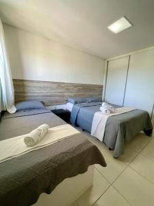 塔曼达雷Flat Beira Mar - Carneiros Beach Resort的一间设有两张床铺和毛巾的房间