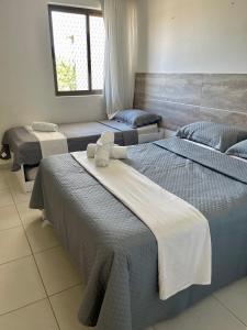 塔曼达雷Flat Beira Mar - Carneiros Beach Resort的一间设有三张床的客房,备有毛巾