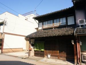 Yokota（一棟貸切）町家体験ゲストハウス「ほんまちの家」〜高岡市の伝統的な古民家～的前面有门的白色建筑