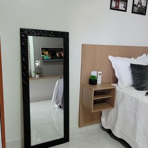 马拉巴Apartamento mobilhado,5 minutos do aeroporto的卧室配有镜子,位于床边