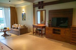 汉班托塔Birds Resort Hambantota的一间带电视和沙发的客厅