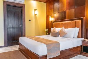 汉班托塔Birds Resort Hambantota的一间卧室配有一张大床和木制床头板