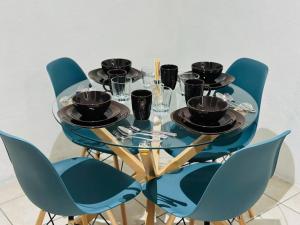 EscuintlaVivienda Céntrica privada的一张带蓝色椅子的餐桌和一张玻璃桌