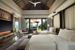 乌鲁瓦图Jumeirah Bali的一间卧室设有四张床和一台平面电视。