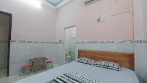 胡志明市Ngọc Mơ Motel的一间卧室配有一张床、一张桌子和一面镜子