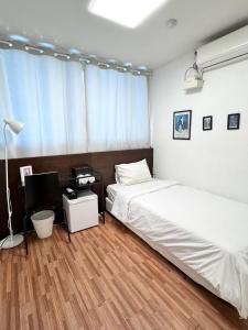 釜山Ekonomy Haeundae Hostel的一间卧室配有两张床和一张带电脑的书桌