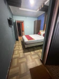 乌提Ooty OWLS NEST INN的卧室配有一张床,位于走廊上