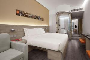 香港Lodgewood by Nina Hospitality Mong Kok的卧室配有一张白色的大床和一张沙发。