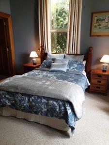 WintonBelvedere Bed & Breakfast的卧室内的一张床位,配有窗户和两盏灯