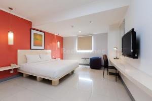 雅加达NamRoom Hotel Glodok RedPartner的一间卧室配有一张床和一台平面电视