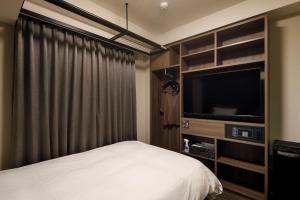 丰桥市Dormy Inn Express Toyohashi的一间卧室配有一张床和一台平面电视