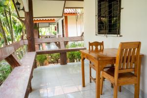 Phra Ae beachLanta School Beach Resort的门廊上的木桌和椅子,享有庭院的景色