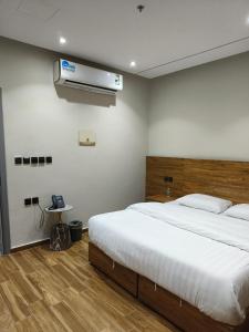 延布قمة راحتي للشقق المخدومة Qimat Rahaity SERVICED APARTMENTS的一间卧室配有一张大床和空调