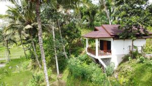 特特巴图Nea Cottage Lombok的树中间的白色小房子