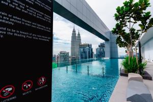 吉隆坡Royce KLCC Kuala Lumpur City Centre by Dormeo Destinations的一座带游泳池的建筑的一侧的标志