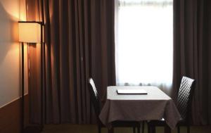 大邱劳昂泽拉酒店的一张桌子和椅子、一张白色的桌子和一个窗口