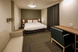 丰桥市Dormy Inn Express Toyohashi的配有一张床和一张书桌的酒店客房