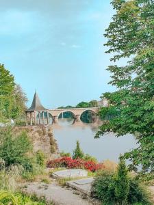 贝尔热拉克Le Vin Quatre的一座有鲜花和桥梁的河桥