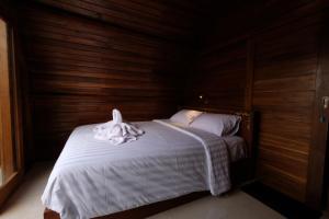 珀尼达岛Garuda Hostel & Accomodation Nusa Penida的一间卧室配有一张床,床上有毛巾