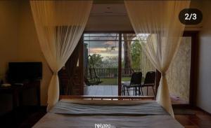 戈尔哈布尔Nisarg Resort的一间卧室配有带窗帘的床和阳台