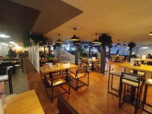 TengizBirlik的一间带木桌和椅子的餐厅以及一间配有桌子的餐厅