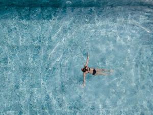 库萨达斯Unique Life Style Hotel的女人在水中游泳