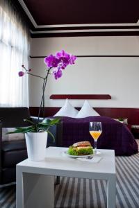 巴登-巴登新卡尔赦弗酒店的一张桌子,上面放着一盘食物和一杯葡萄酒