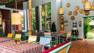 RuhengeriRoom in Guest room - Isange Paradise Resort的餐厅设有桌椅和窗户。