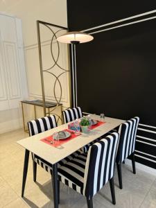 吉隆坡Axon Residence By Luxury Suites的餐桌、条纹椅子和黑板
