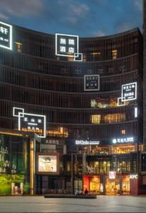 重庆无隅酒店(重庆两江幸福广场店)的一座大建筑,晚上有标志