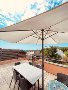 罗列特海岸Sunny apartment Sa Boadella big solarium sea view的庭院内的白色遮阳伞,配有桌椅
