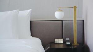 高雄高雄洲际酒店的一张桌子上的带灯的床,床边