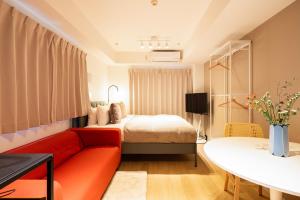 东京Section L Residence Ginza的客厅配有红色的沙发和床。