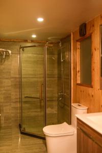KūkkālLUXEGLAMP ECOSTAYS的浴室设有玻璃淋浴间和卫生间