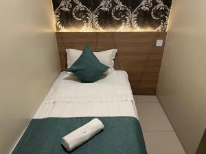 关丹KUANTAN BESERAH BUDGET HOTEL的一张带绿色和白色毯子及枕头的小床