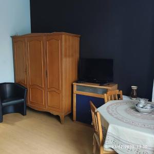 布鲁塞尔Room in Guest room - Chambre A Brucelles D的一间卧室配有木制橱柜和一张桌子及电视