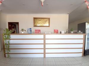 TelagaMaherza Syariah Homestay Gorontalo RedPartner的一间白色和棕色的房间里的一个柜台