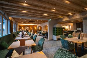 埃尔毛Hotel Hochfilzer的一间带木桌椅的餐厅以及一间带桌椅的餐厅。