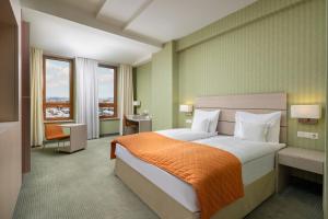 锡比乌锡比乌阿娜塔金色郁金香酒店的一间卧室配有一张带橙色毯子的大床