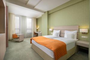 锡比乌锡比乌阿娜塔金色郁金香酒店的酒店客房,配有一张带橙色毯子的床