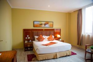 达累斯萨拉姆Tiffany Diamond Hotels LTD - Makunganya的一间卧室,卧室内配有一张大床