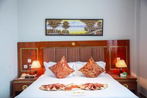 达累斯萨拉姆Tiffany Diamond Hotels LTD - Makunganya的一间卧室配有一张带两个枕头的床