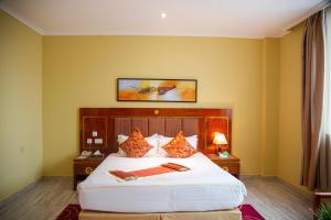 达累斯萨拉姆Tiffany Diamond Hotels LTD - Makunganya的卧室配有一张白色大床