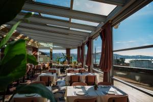 伊斯坦布尔奥塔科伊公主酒店的餐厅设有桌椅和大窗户。