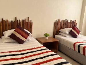 清莱Chat Residence Hotel的一间卧室设有两张床和木制床头板